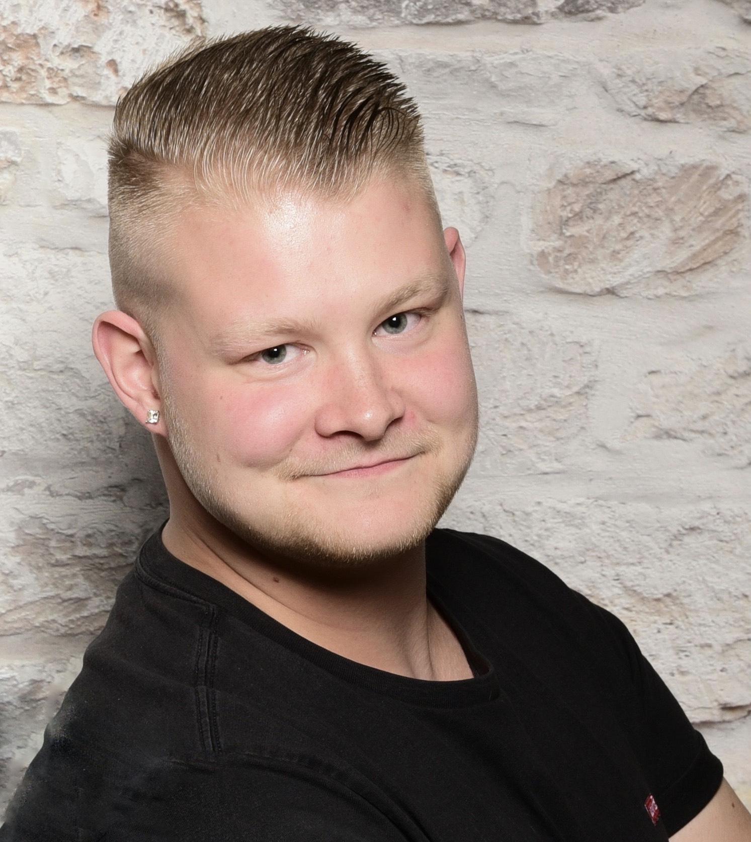 young man wearing shades and a hat with a beard, tattos and ear piercings